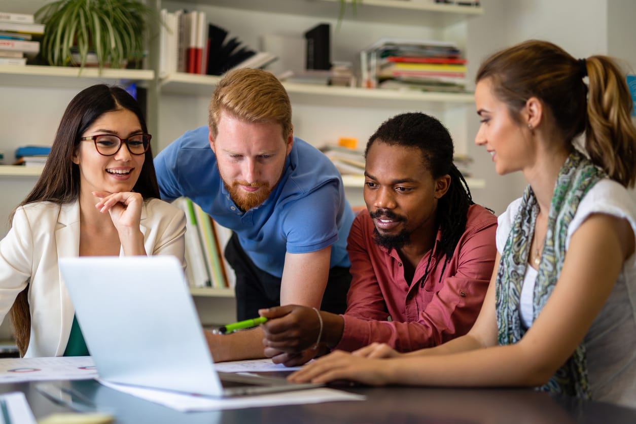 group of teachers or colleagues reviewing data on a laptop