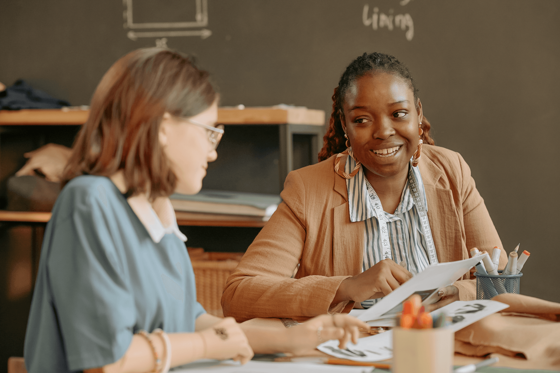 two teachers or colleagues reviewing student work in a classroom